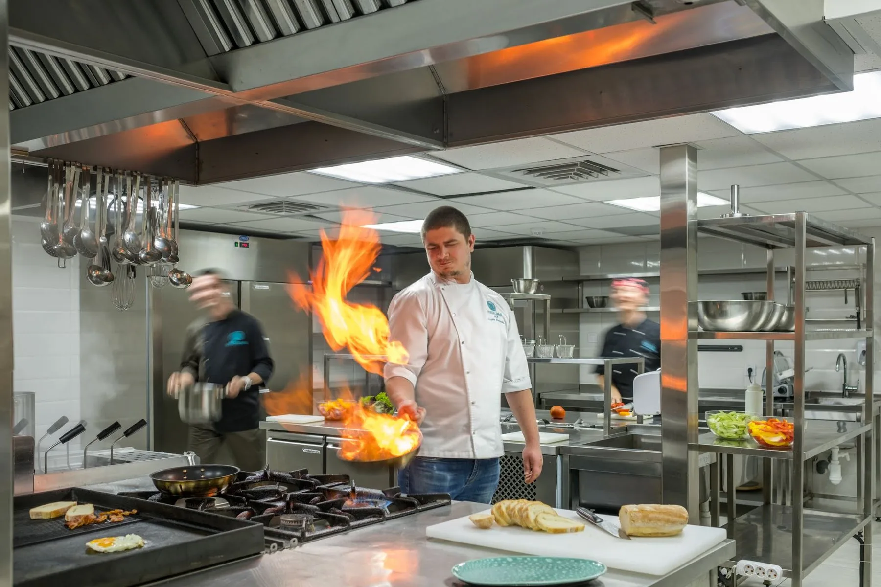 Chef flambéing a pan in a restaurant kitchen