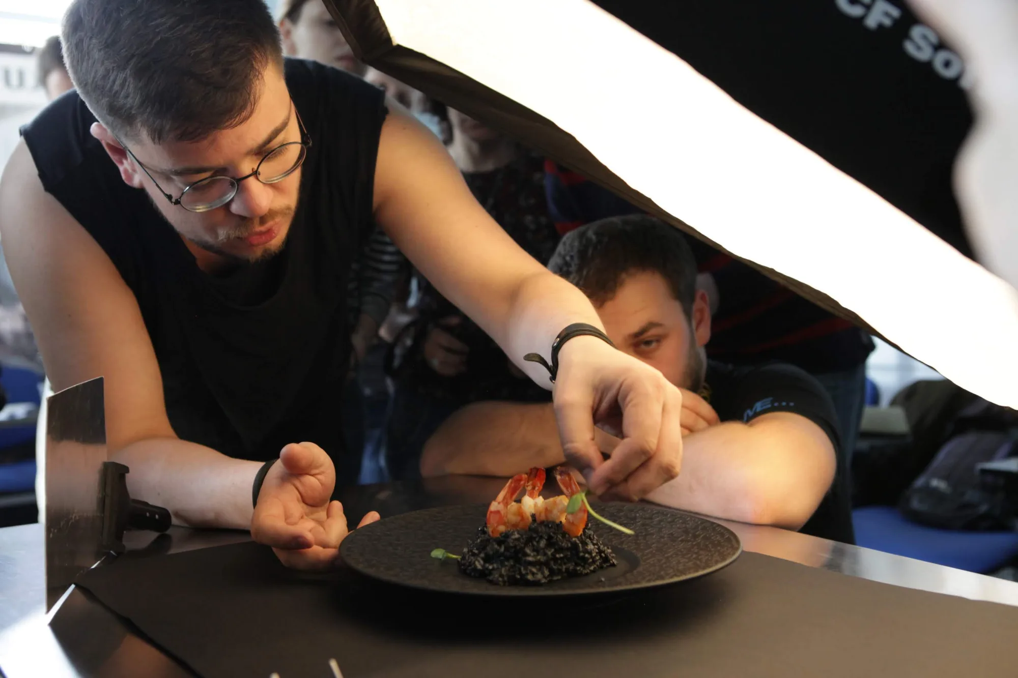 Alex Slyadnev plating a dish under a softbox