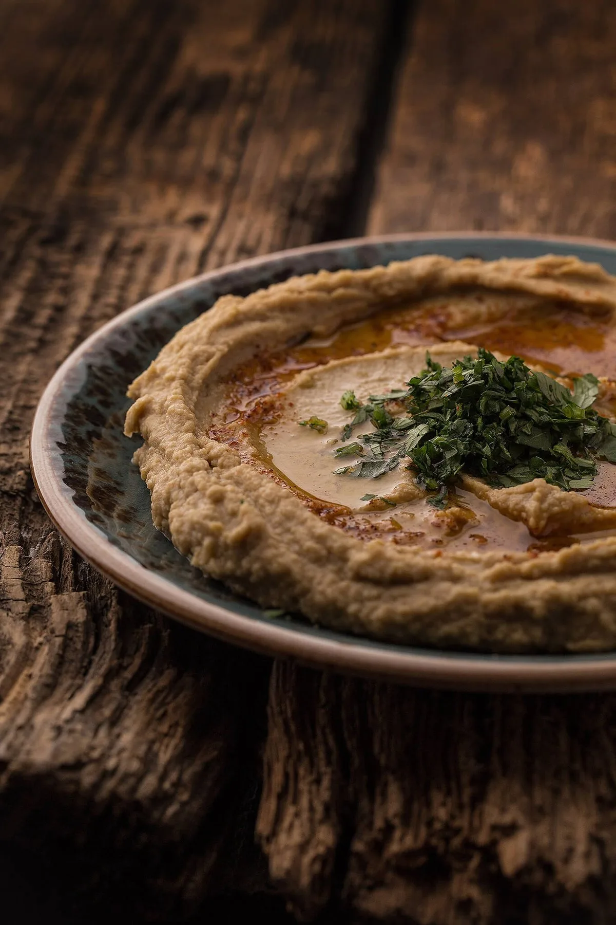 Hummus with herbs on a wooden table