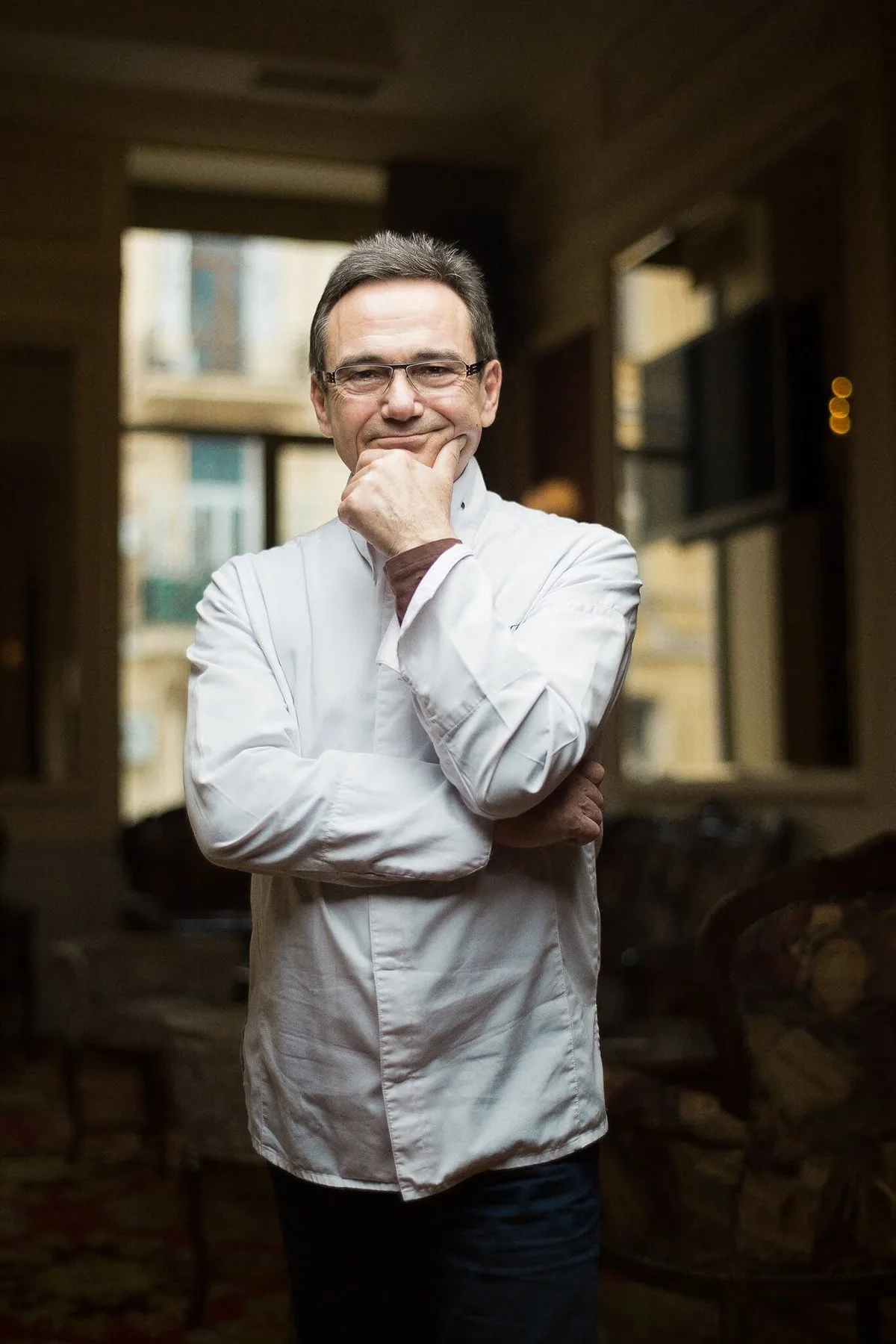 Chef in a white jacket in a restaurant dining room