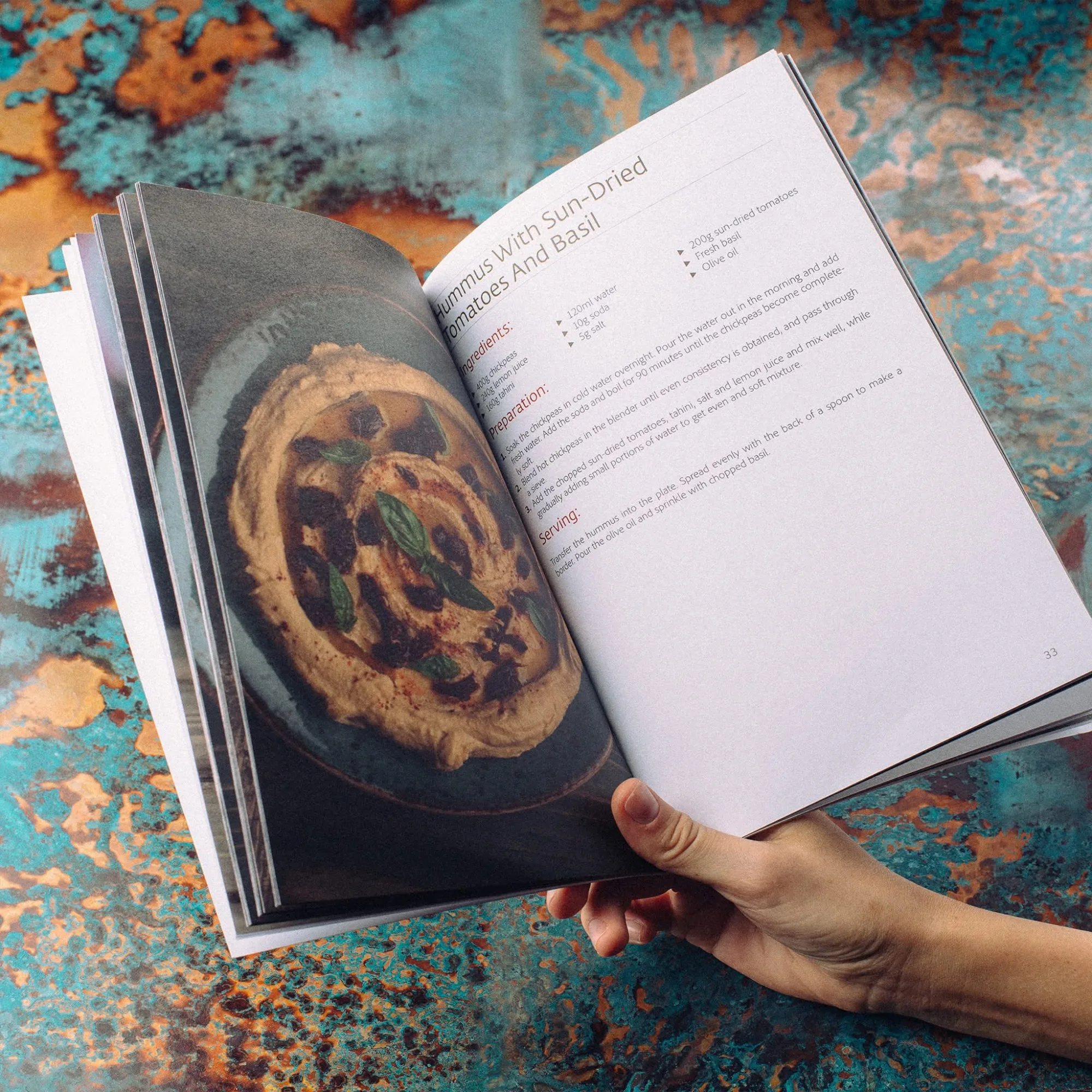 Hummus cookbook open at hummus with sun-dried tomatoes and basil