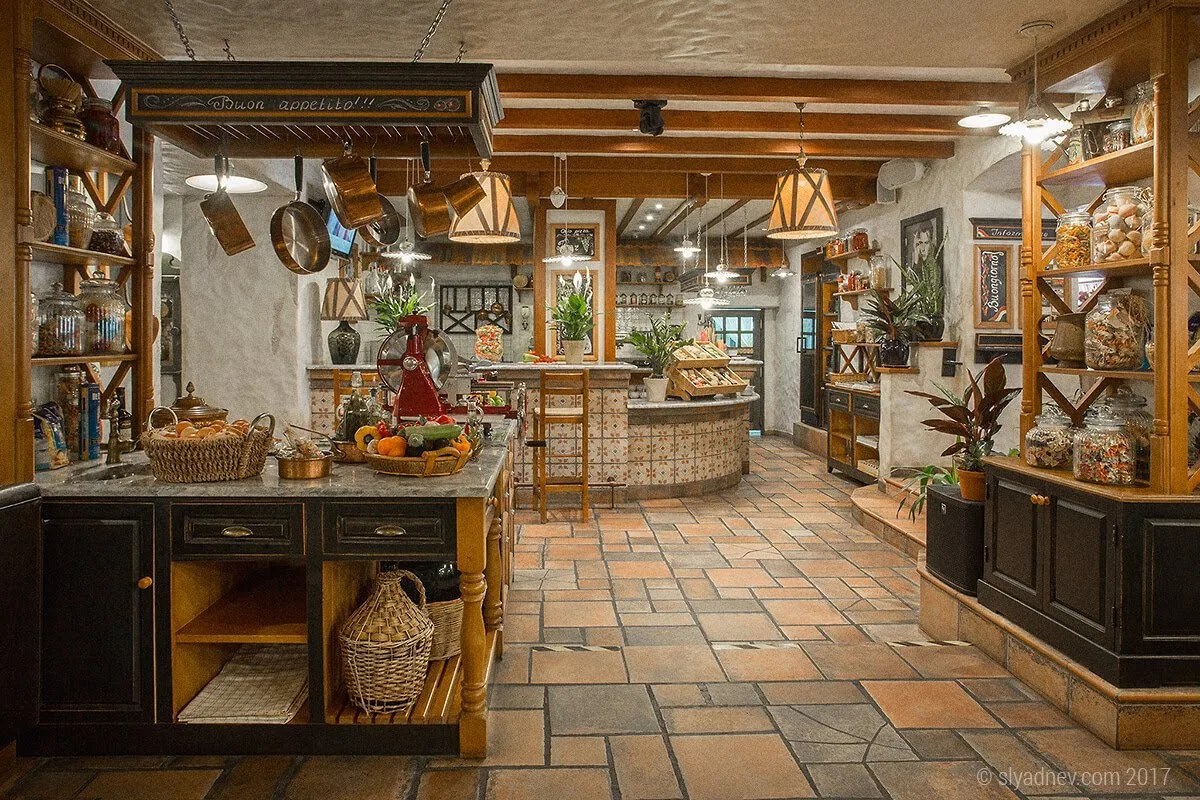 Restaurant interior with an open kitchen and a tiled floor
