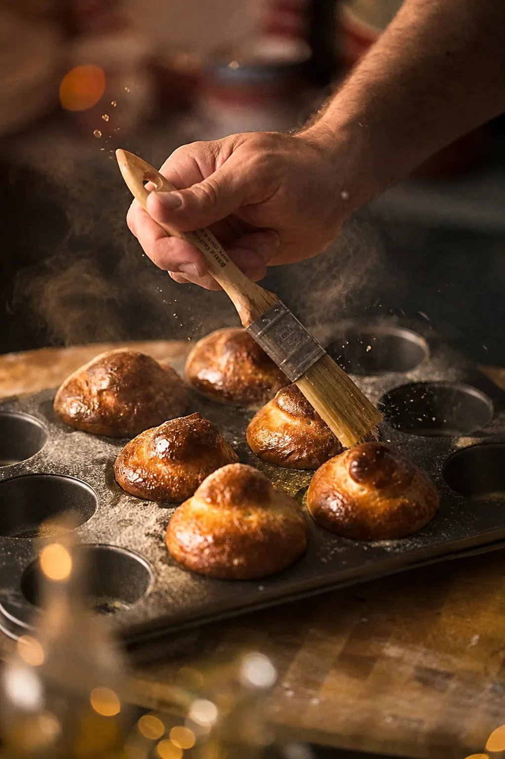 Brushing glaze onto pastries in a baking tray