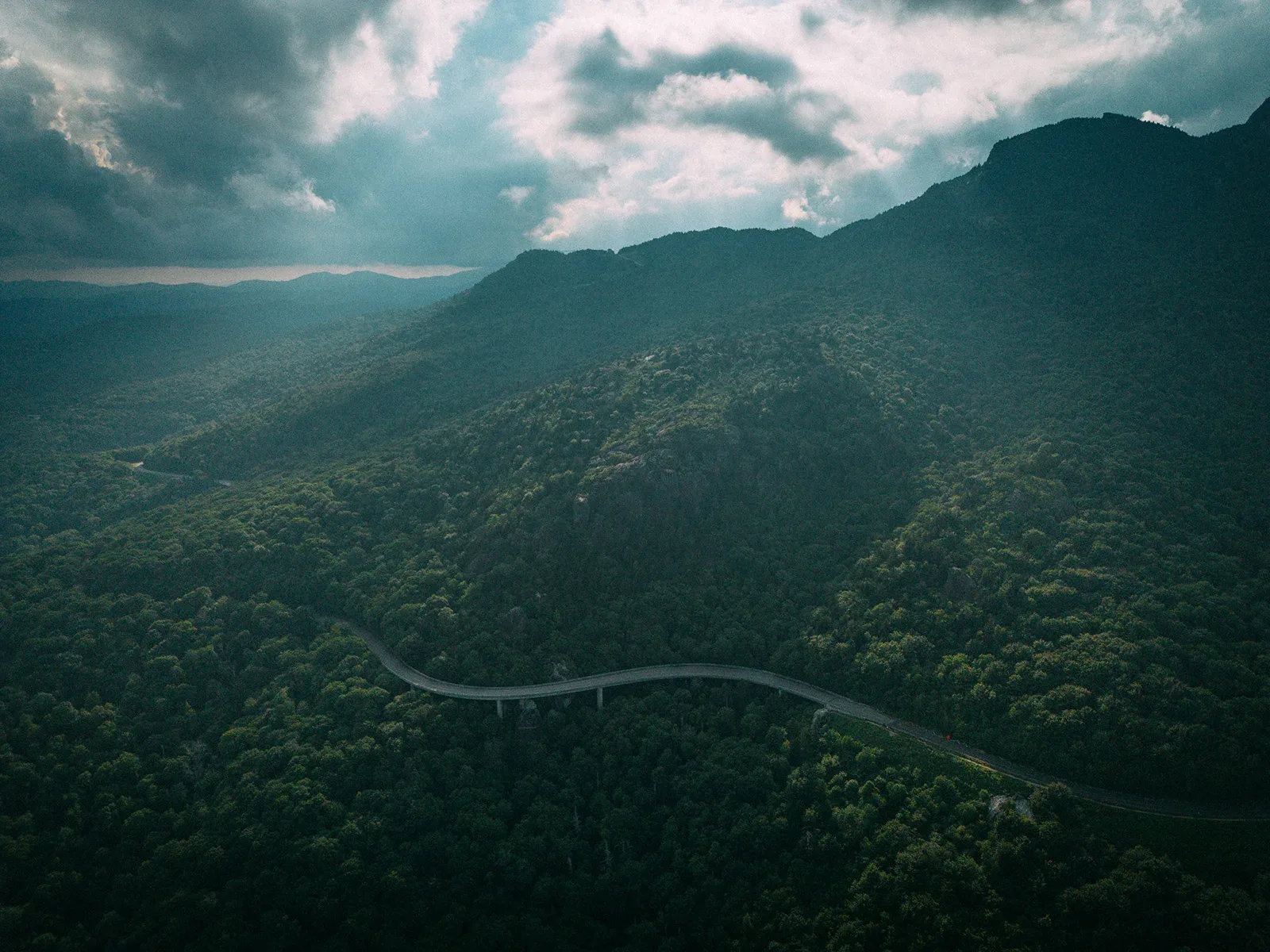 Aerial drone view of the S-shaped Linn Cove Viaduct curving around Grandfather Mountain on the Blue Ridge Parkway in North Carolina
