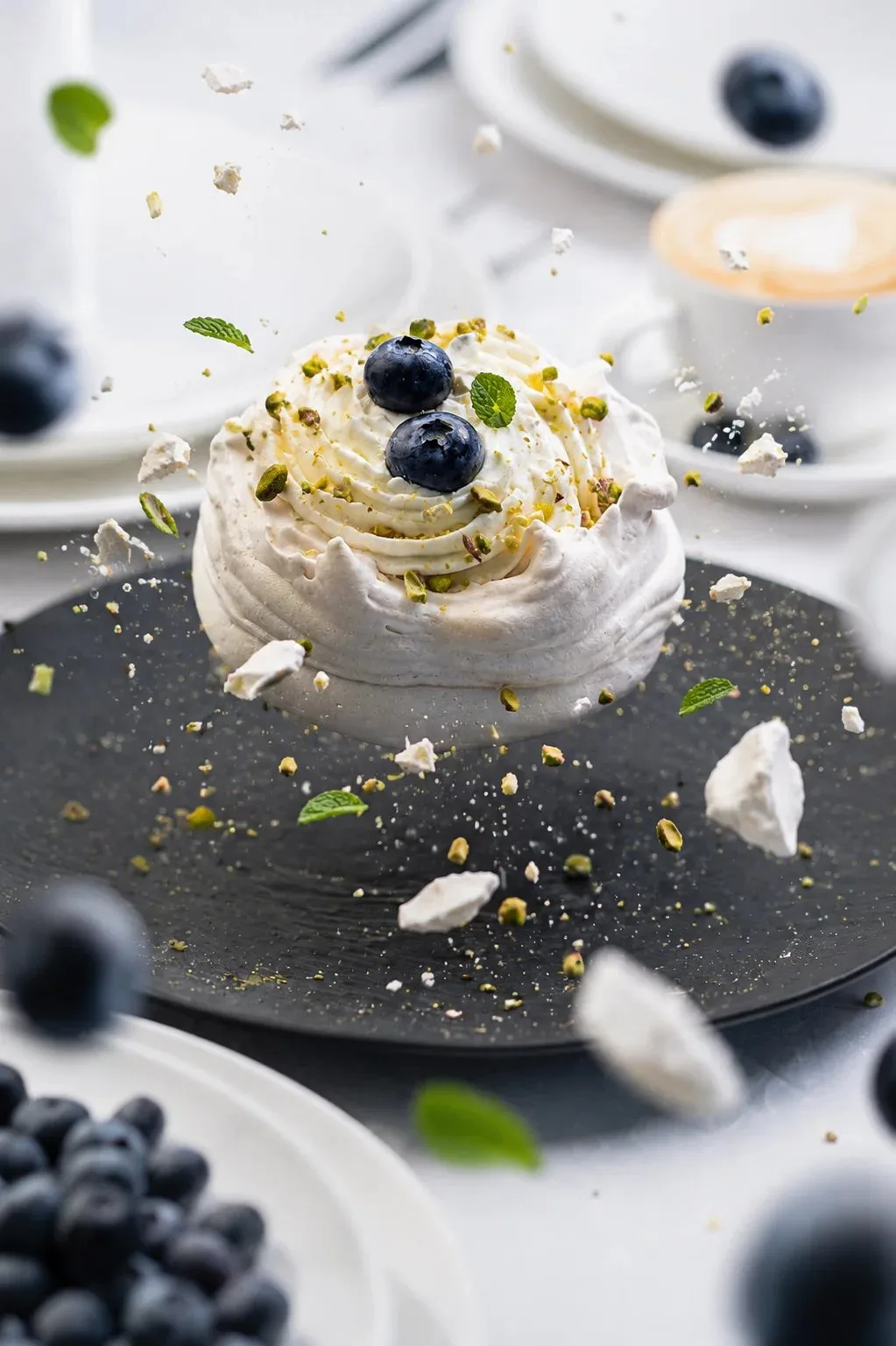 Dessert with blueberries and meringue on a dark plate