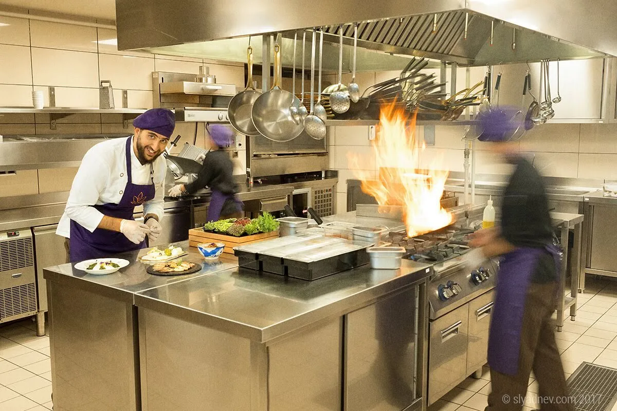 Chefs at work in a restaurant kitchen with flames